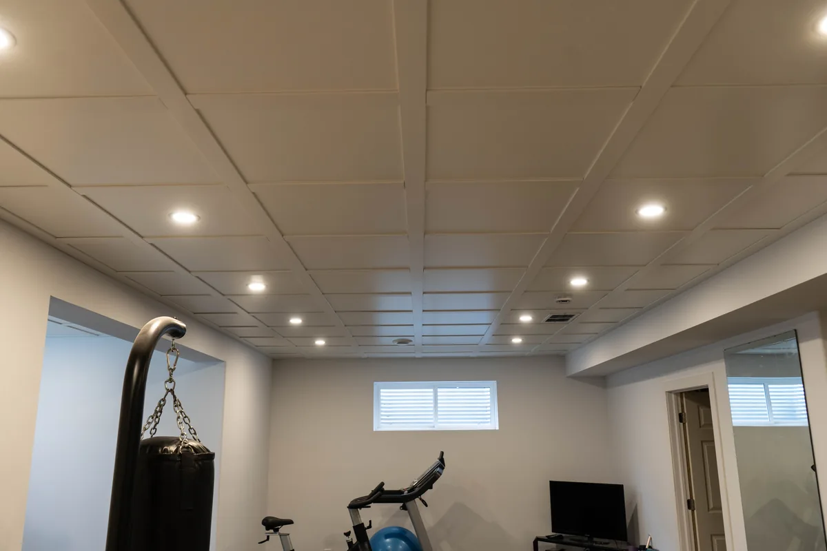 Renovated basement room with finished ceiling, recessed lights and open floor area