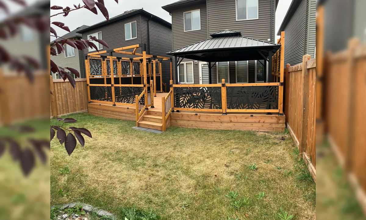 Completed wood deck and outdoor gathering structure in a residential backyard